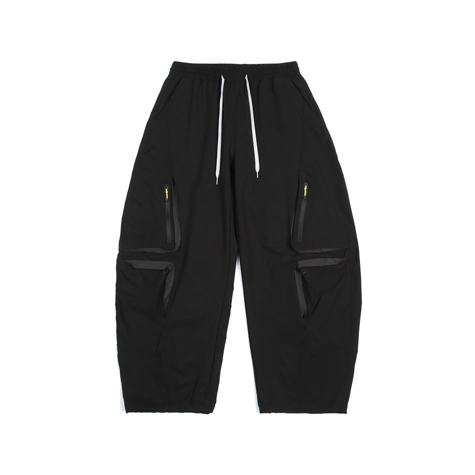 Black wide-leg cargo pants with white drawstring, yellow zipper pulls and flap leg pockets, front flat view
