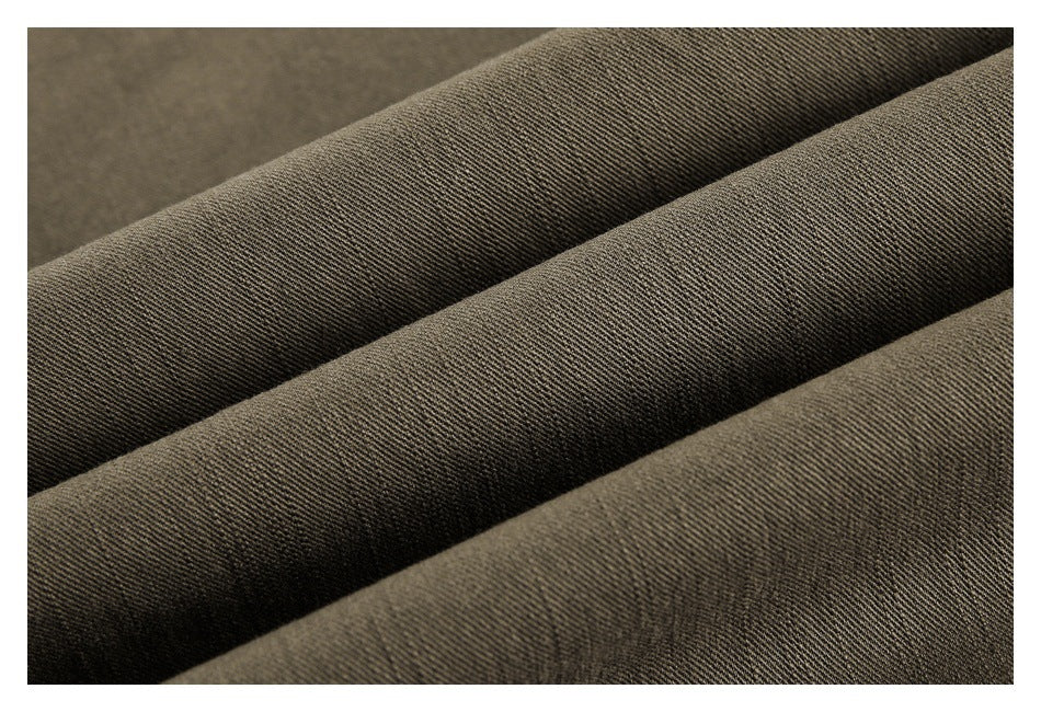 Close-up of dark olive-brown woven fabric arranged in diagonal folds.