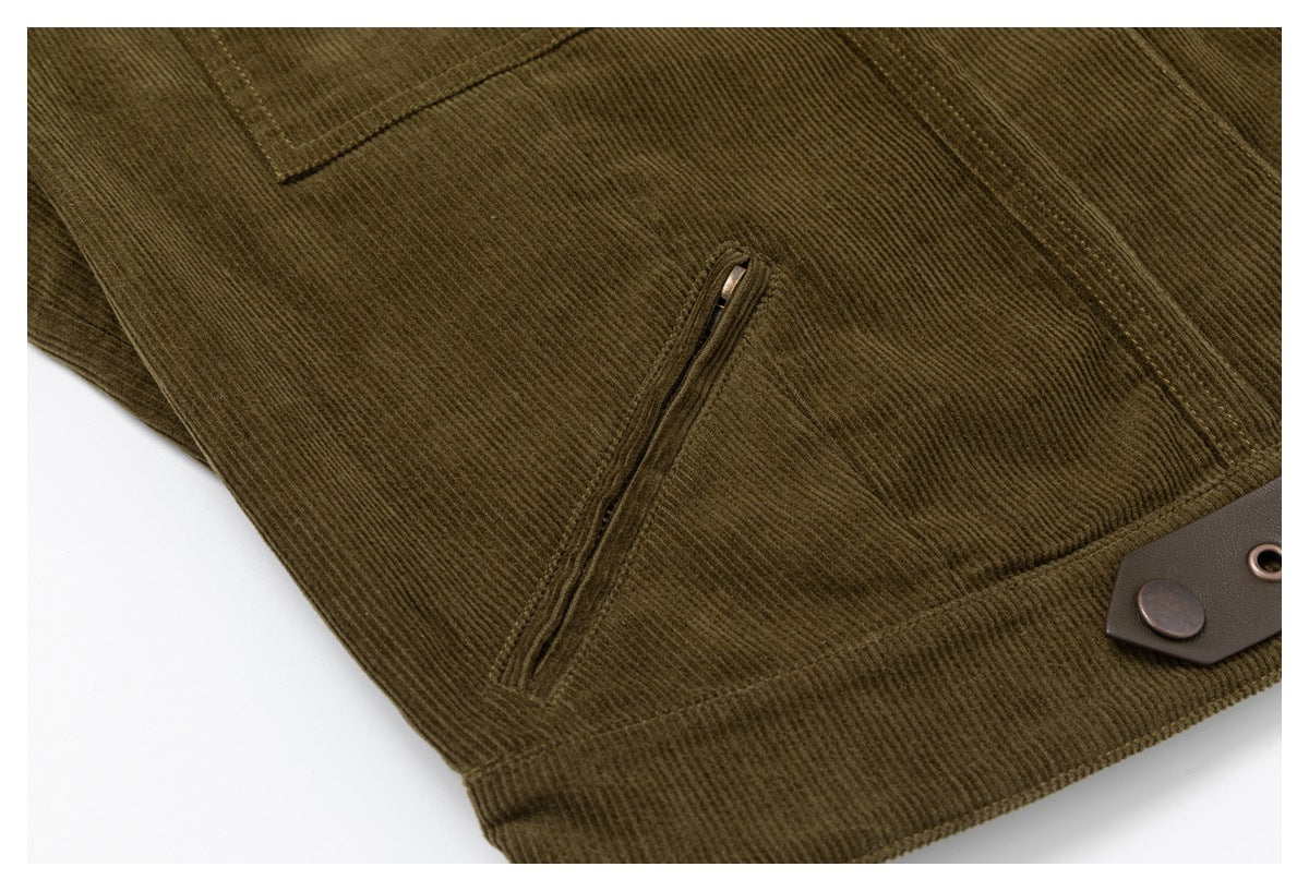 Close-up of the olive corduroy jacket's angled zip pocket and lower hem with a snap-fastened tab.