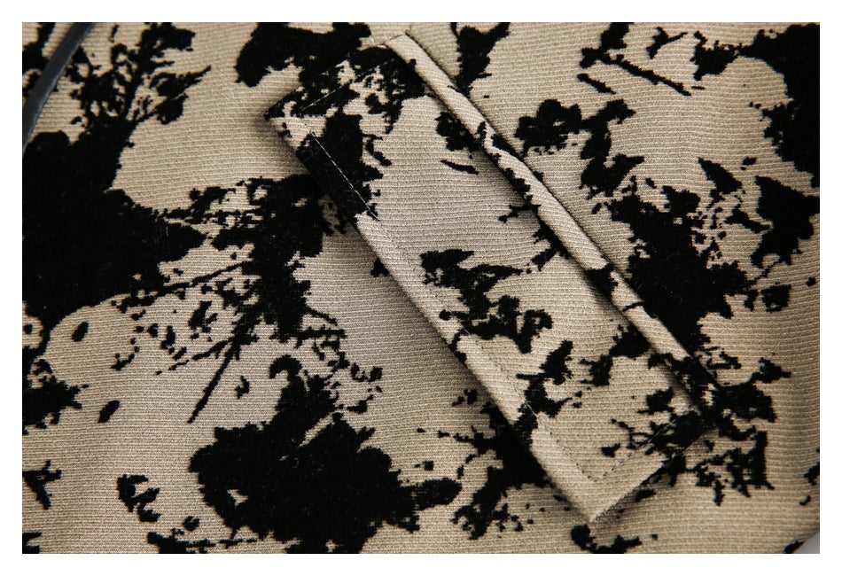 Close-up of narrow matching fabric ties across tan cloth with a black abstract floral pattern.