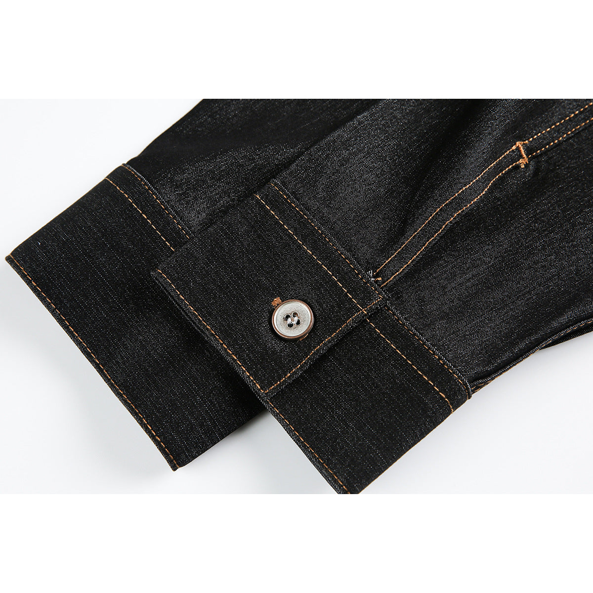 Close-up of dark denim shirt cuffs with silver buttons and orange contrast stitching.