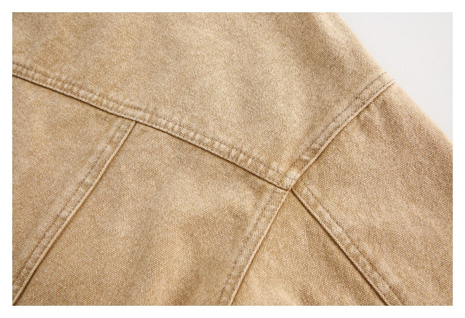 Close-up of intersecting stitched seams on tan garment fabric.