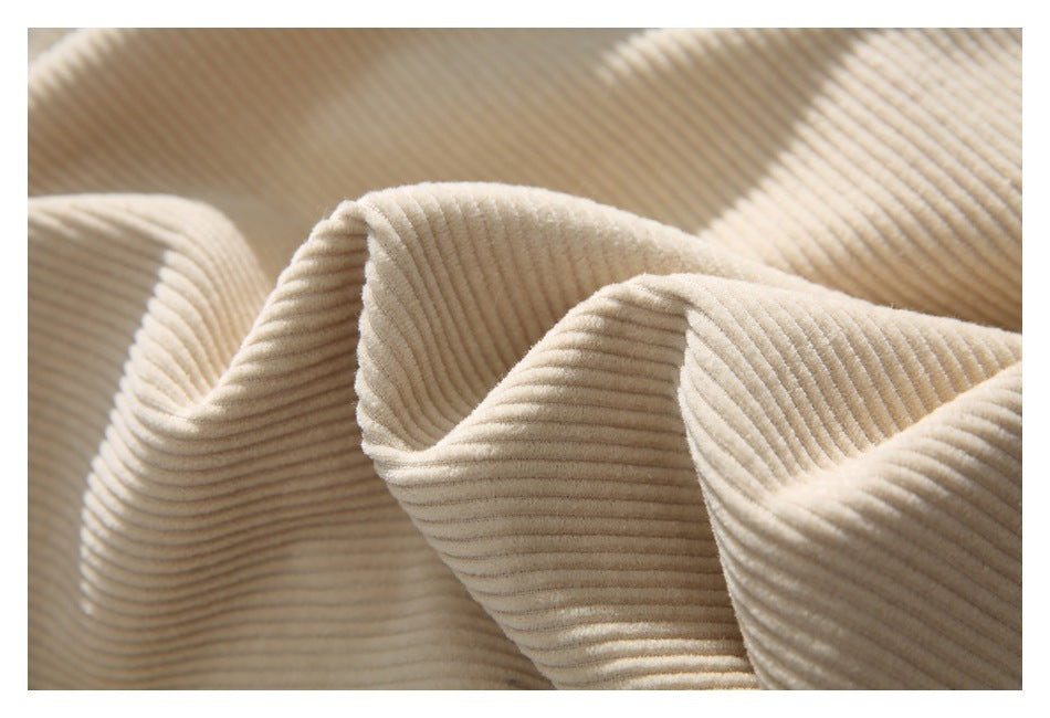Close-up highlighting the cream garment's soft-looking ribbed surface and folds.