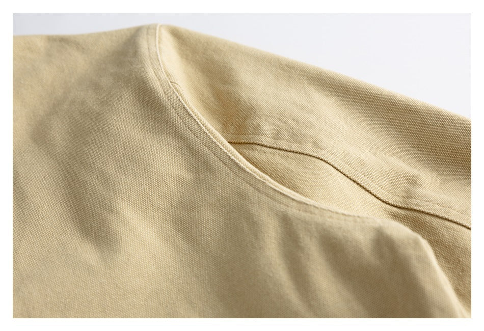 Close-up of stitched seams across the tan jacket's shoulder and sleeve.