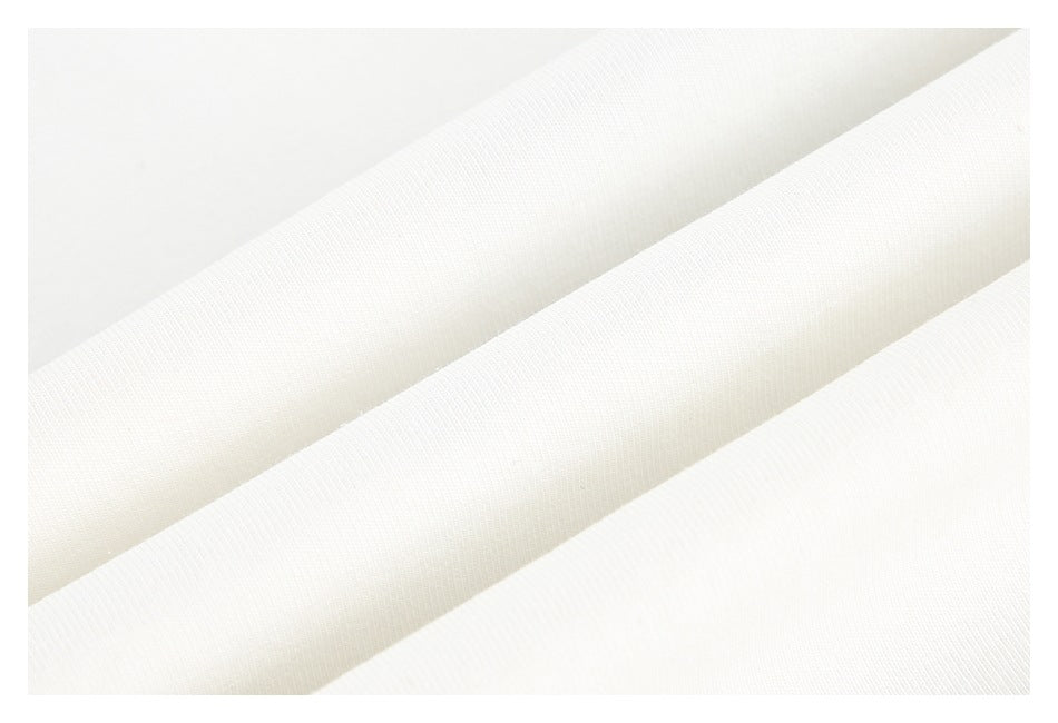 Close-up of softly folded white fabric showing its fine surface texture.