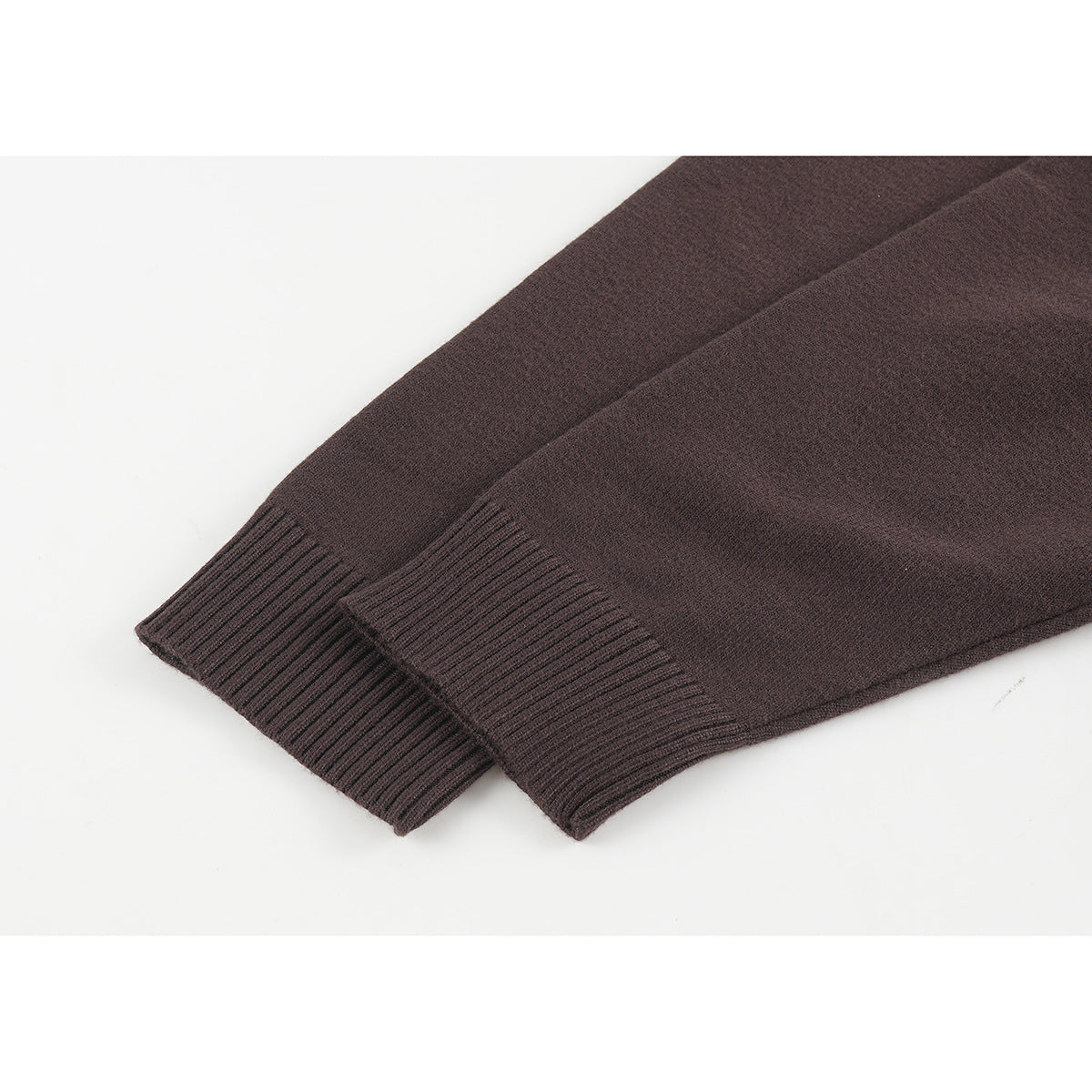 Close-up of the dark brown sweater's long sleeves and ribbed cuffs.