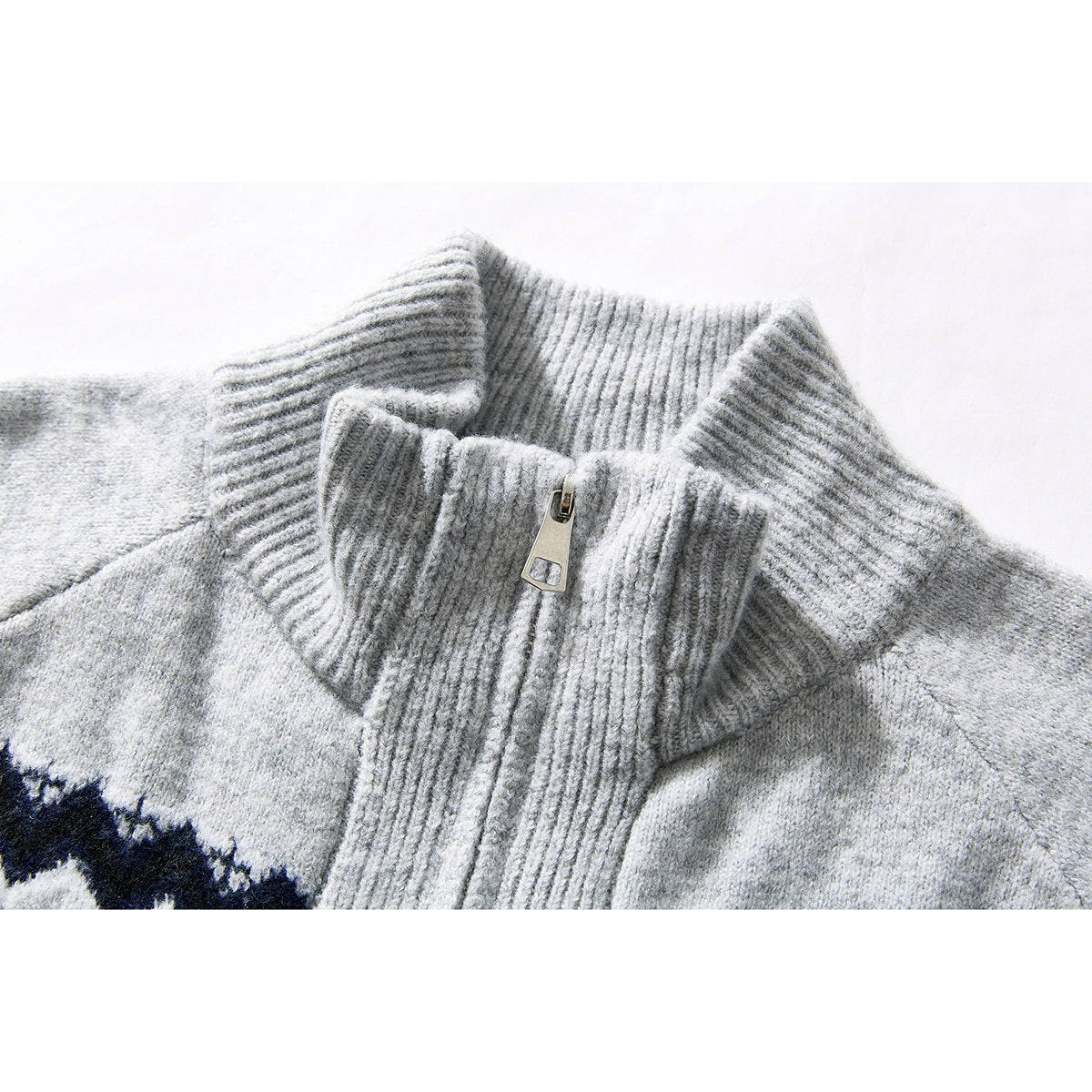 Close-up of the gray cardigan’s ribbed stand collar and zipper, with part of its navy-and-white pattern visible.