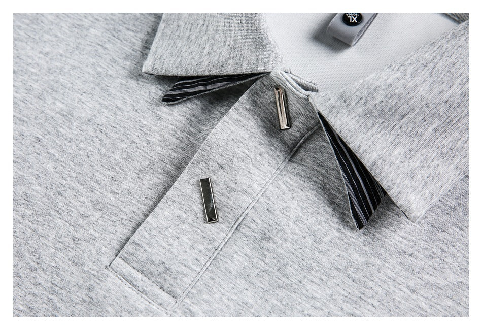 Close-up of the gray shirt's collar, striped trim, button tab and chest pocket with a metal accent.