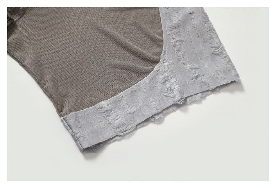 Close-up of the taupe mesh sleeve joined to the textured light gray fabric and hem.