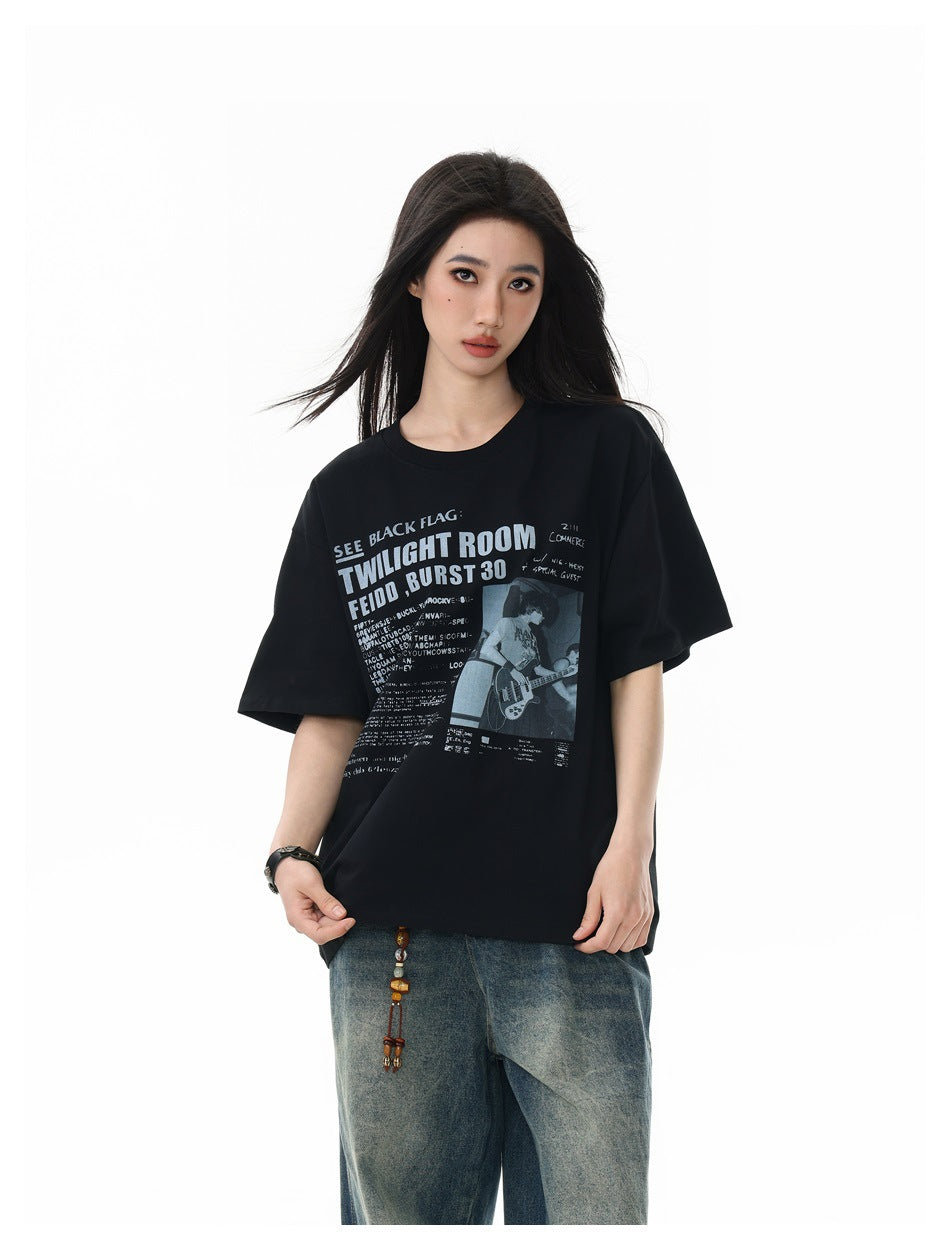 Closer front view of a model wearing an oversized black graphic T-shirt with blue jeans.