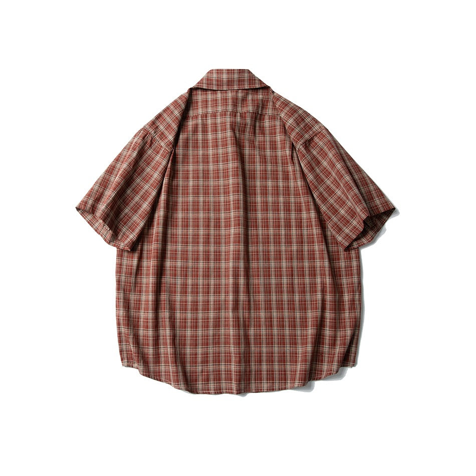 Back view of a rust-red plaid short-sleeve button-up shirt laid flat, with a pointed collar and curved hem.