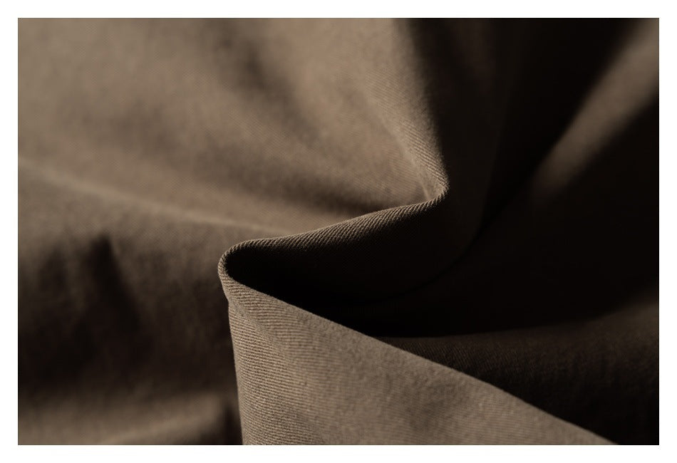 Close-up showing the brown garment fabric's woven texture and folds.