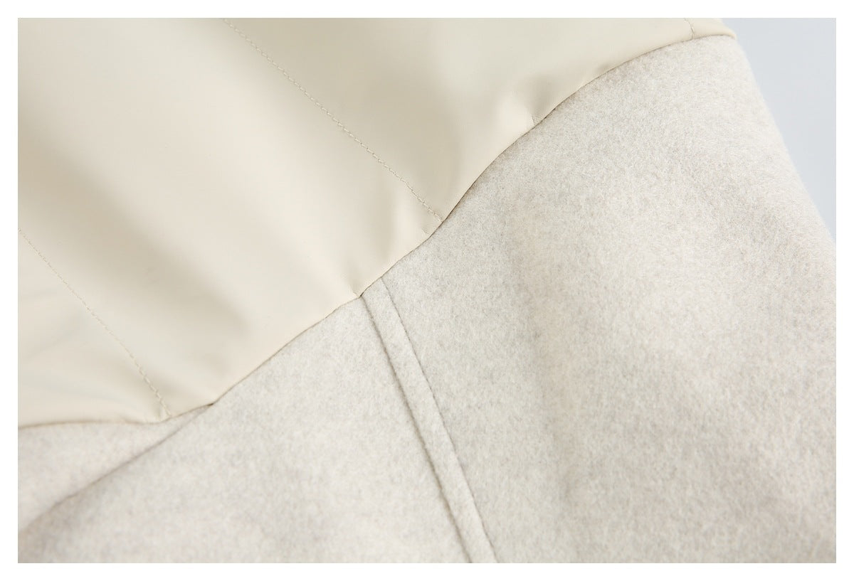 Close-up of a cream garment showing a smooth stitched panel beside a pale textured section.