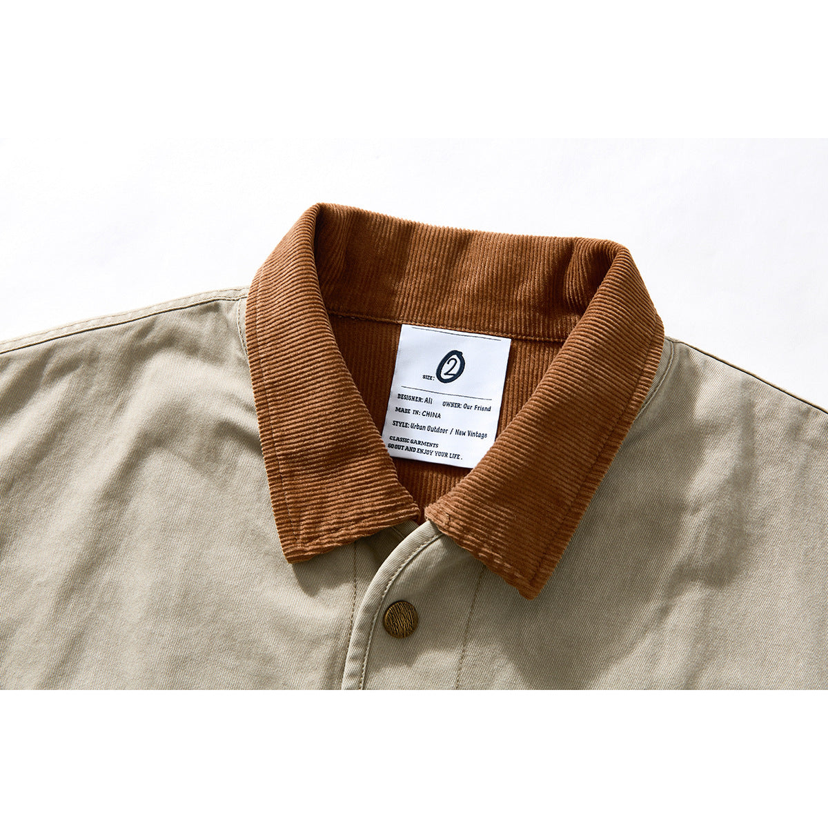 Close-up of a beige jacket with a brown corduroy collar and an inner label.