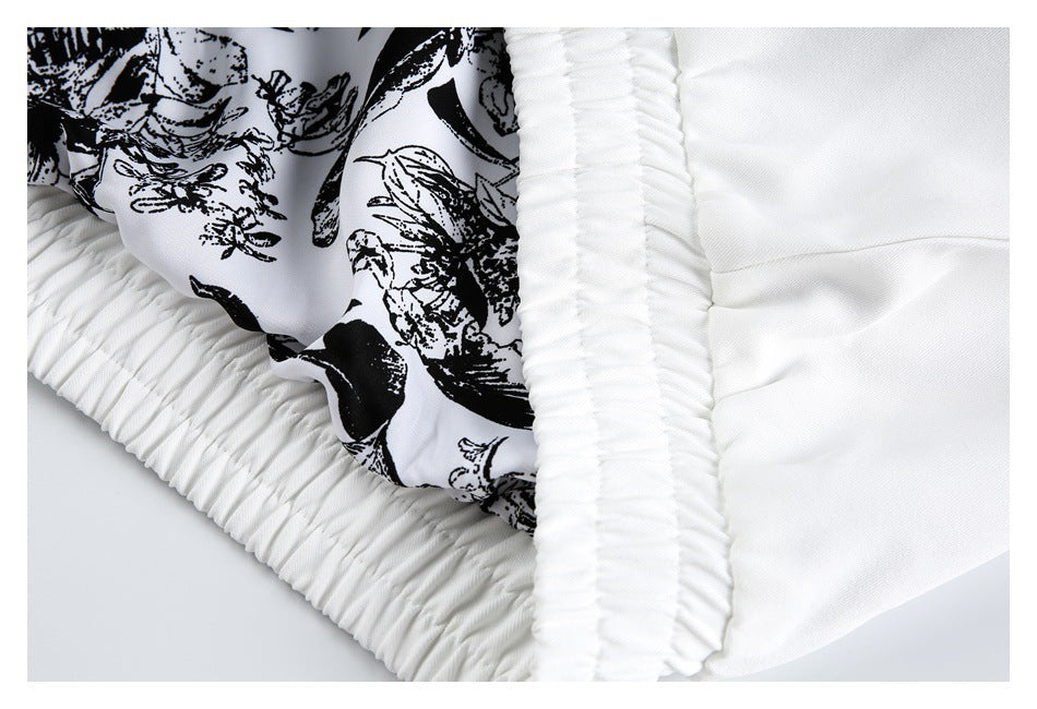 Close-up of a gathered white elastic edge beside black-and-white printed fabric.