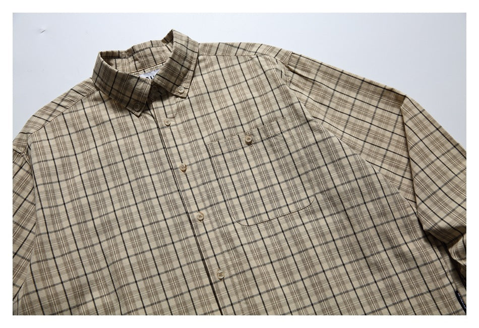 Angled front view of a beige plaid button-up shirt with a pointed collar, buttons, and a chest pocket.