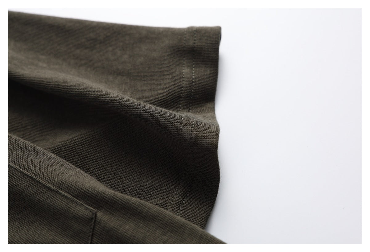 Close-up of a dark olive-brown sleeve edge and double-stitched seam.