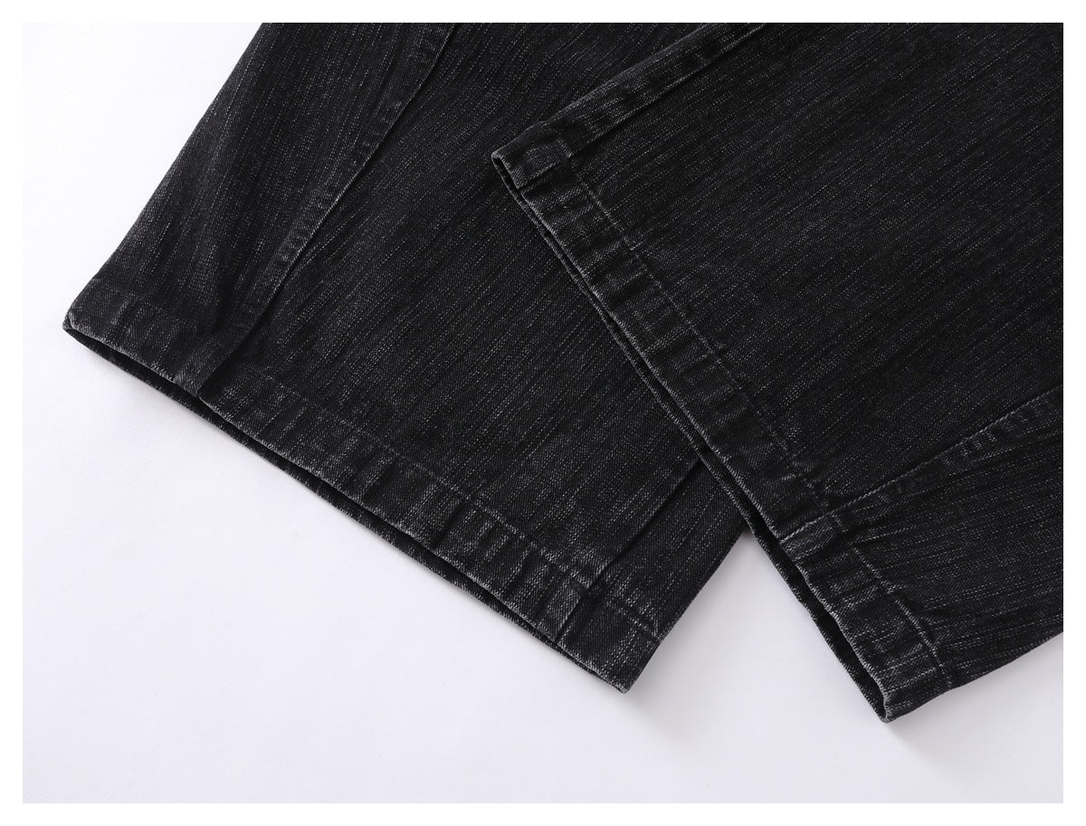 Close-up of two black jean hems overlapping, with visible stitching and textured fabric.