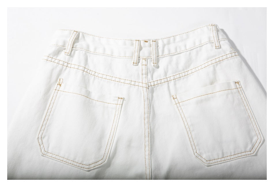 Back view of white trousers laid flat, with two patch pockets, belt loops and tan stitching.