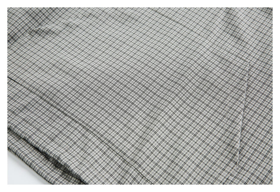 Light gray and black plaid fabric spread flat, with a folded edge visible at the lower left.