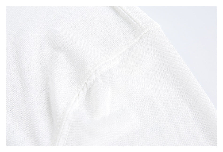 Close-up of a white shirt's shoulder seam and sleeve stitching.