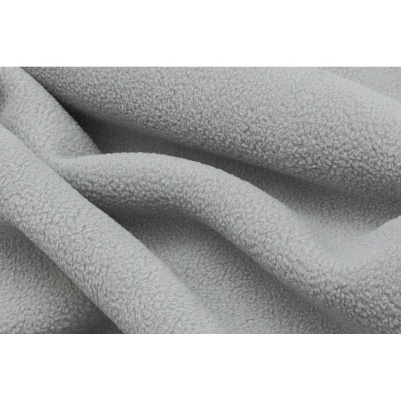 Extreme close-up of the light gray jacket's textured fleece surface and folds.