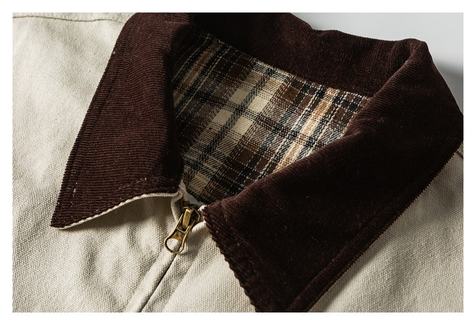 Close-up of a beige garment with a dark brown collar, plaid lining, and brass zipper pull.