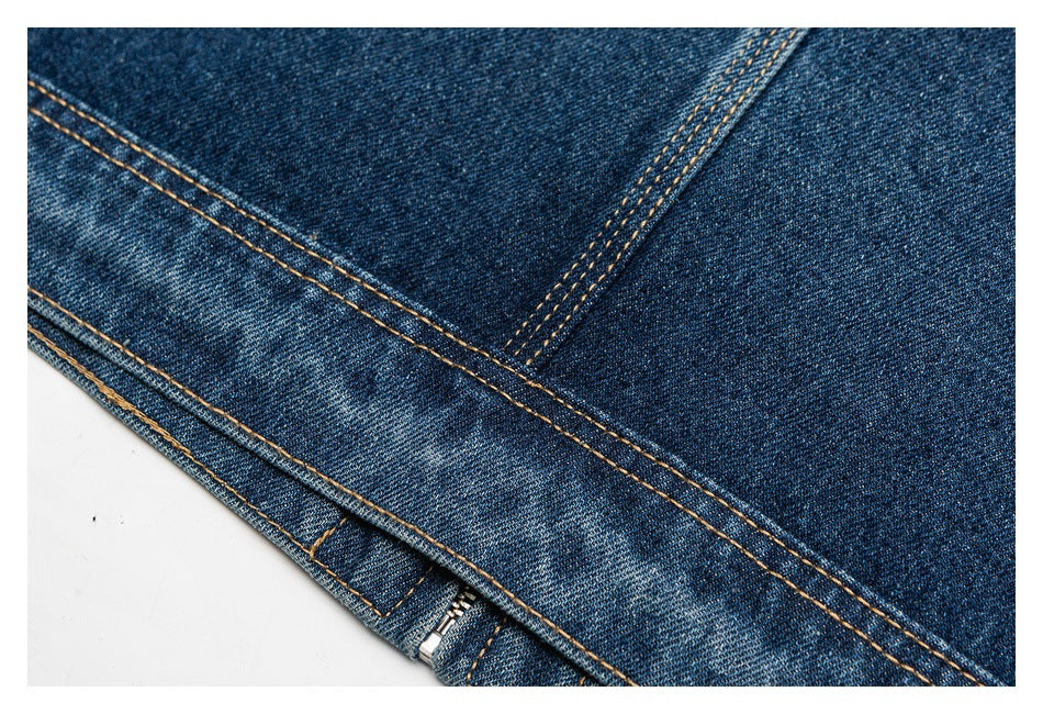 Close-up of dark blue denim seams with tan topstitching and a partially visible metal zipper.