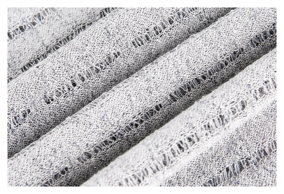Extreme close-up of light gray and charcoal striped knit with open ladder-like stitch details.