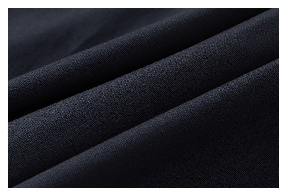Close-up of dark navy fabric arranged in soft folds, showing its fine woven texture.