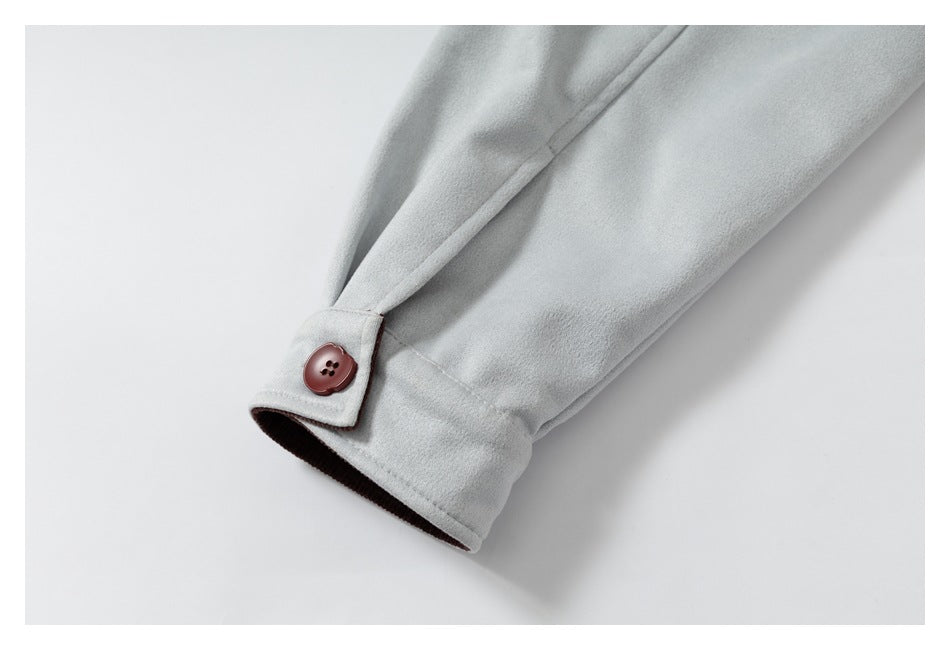 Close-up of a light gray coat sleeve cuff with a burgundy button and dark inner lining.