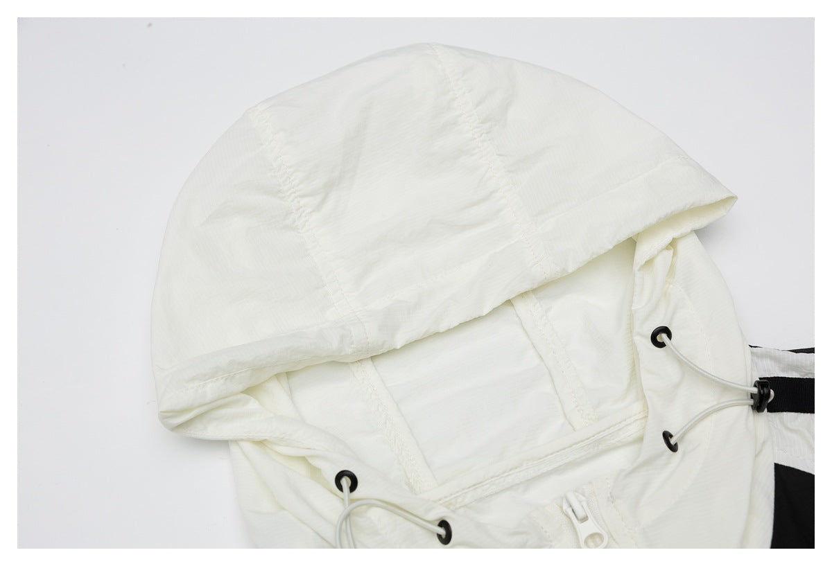 Close-up of the white hood, showing its panel seams, elastic drawcords, black eyelets, and toggle.