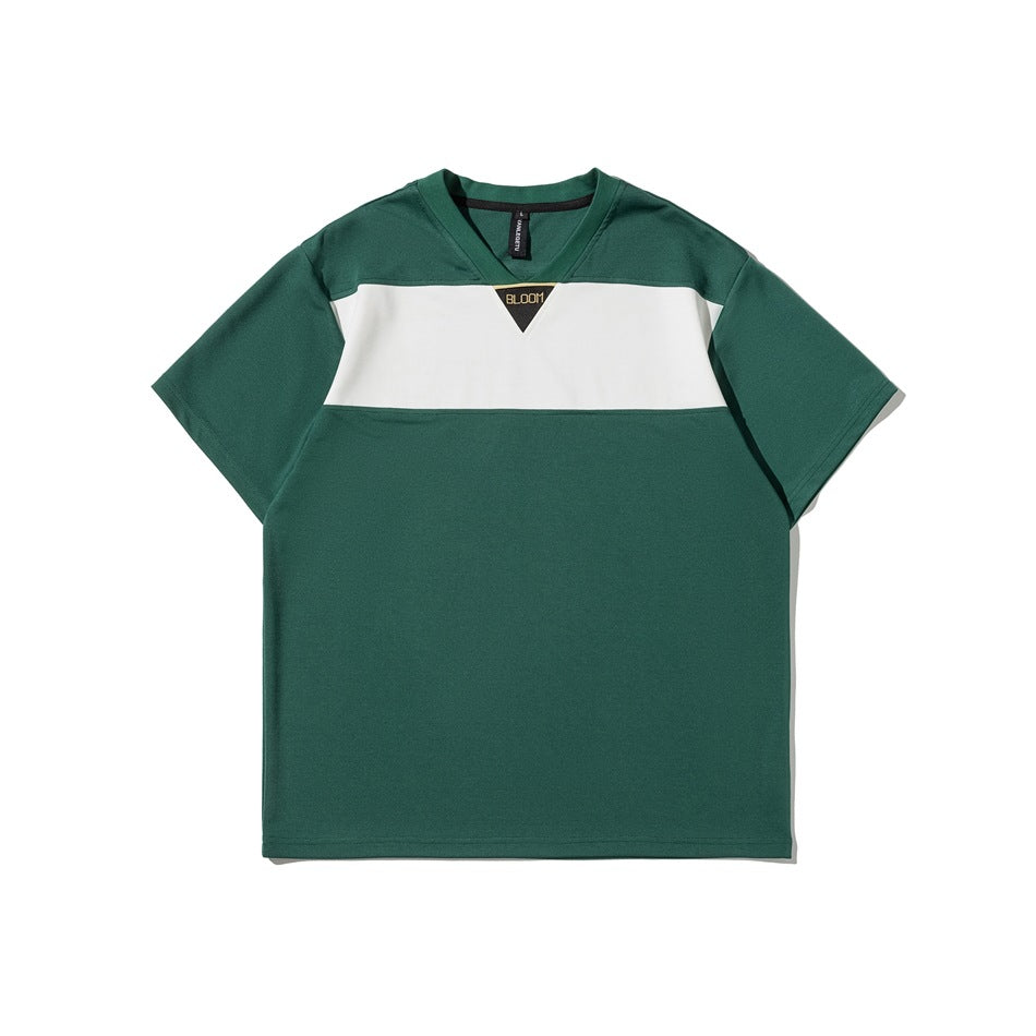 Green short-sleeve V-neck T-shirt with white chest color-block and black triangle BLOOM patch, flat lay
