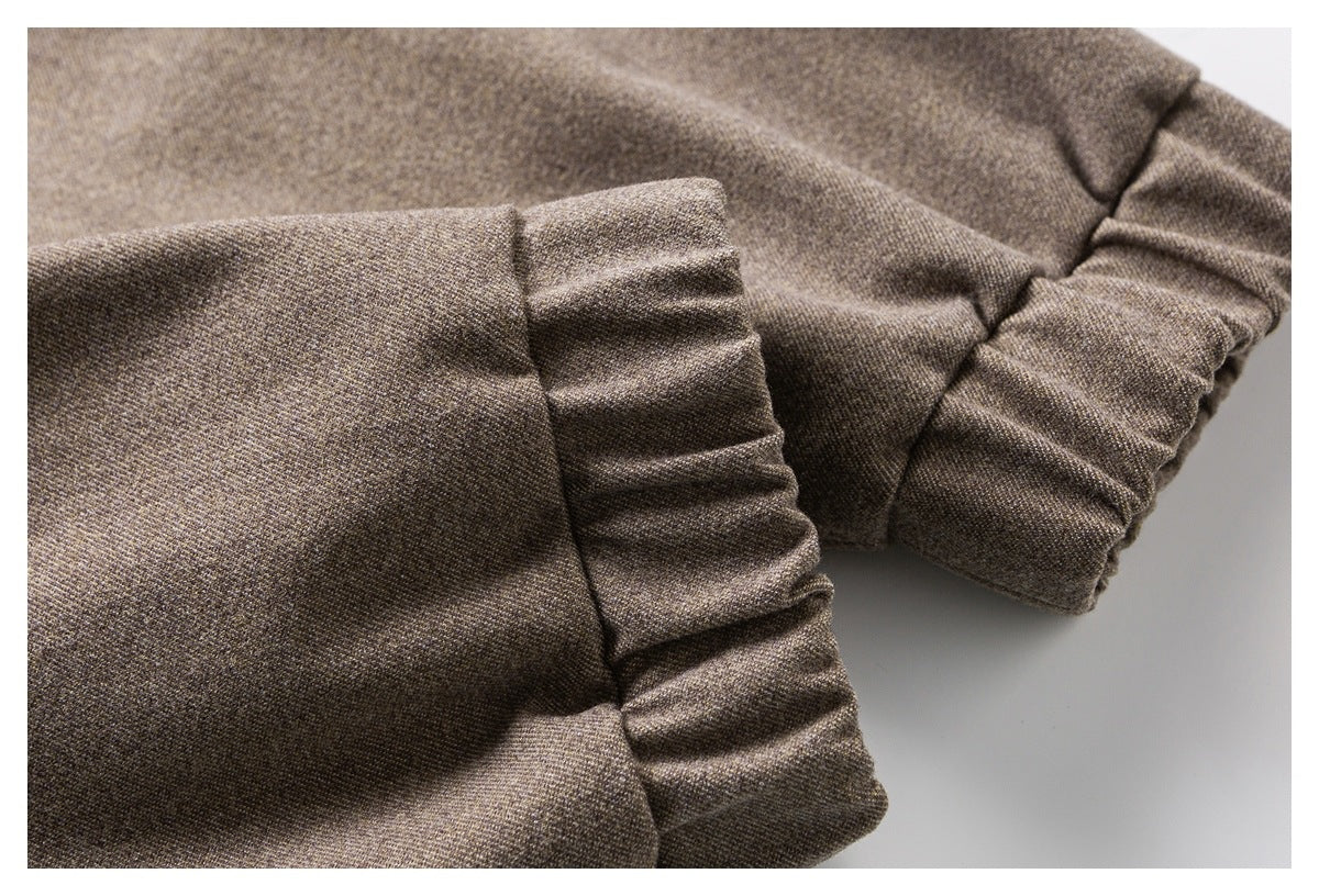 Close-up of gathered sleeve cuffs on a brown textured coat.