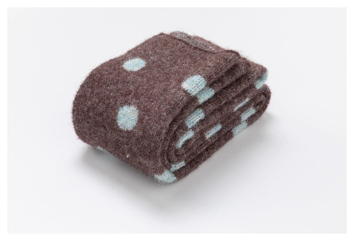 Brown knit garment with pale blue motifs folded into a compact bundle.
