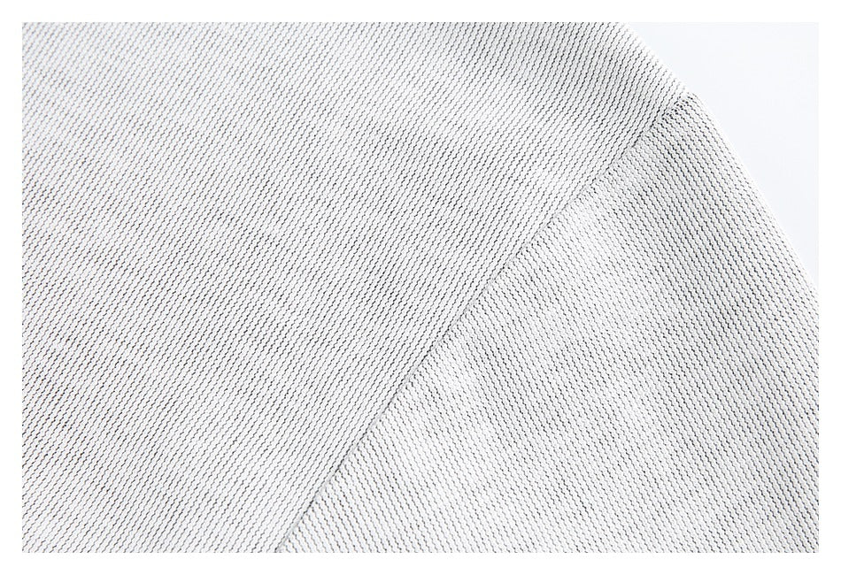 Close-up of light gray textured fabric with a curved diagonal seam.