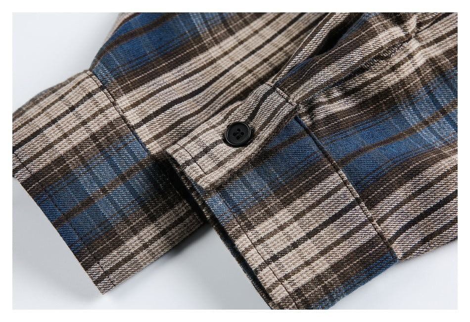 Close-up of the plaid shirt's cuff and buttoned sleeve placket.