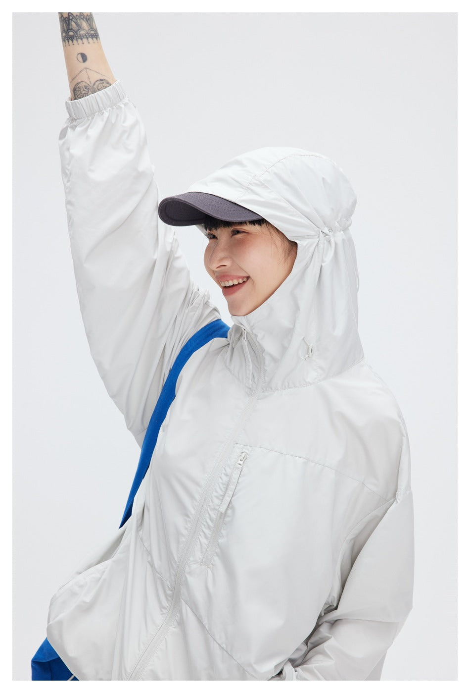 Model wearing a white hooded jacket with the collar raised around the face; close-up of the hood and front.