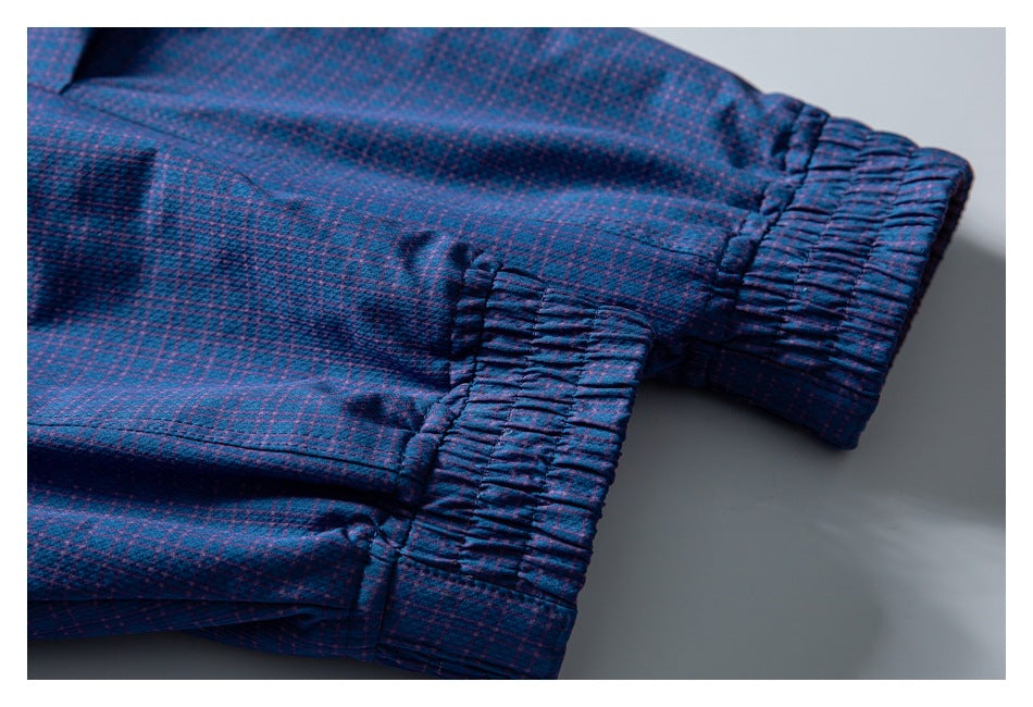 Close-up of gathered elastic sections on a navy and purple plaid garment.