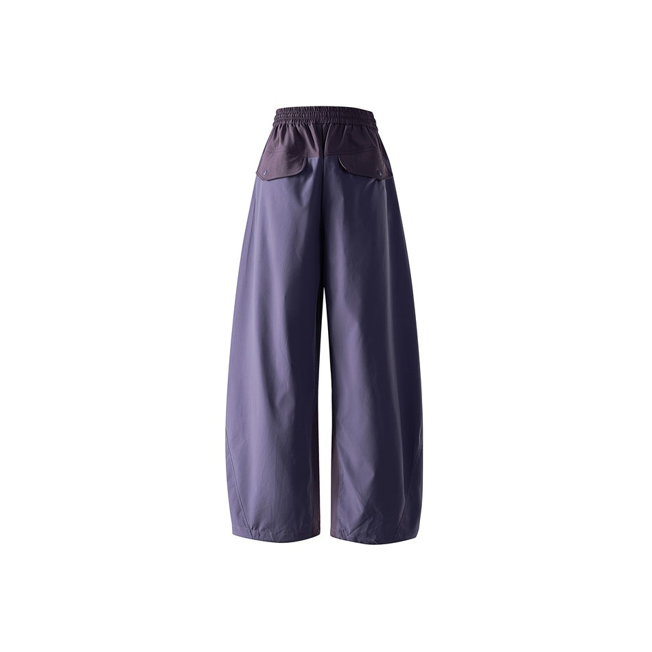 Rear view of purple wide-leg pants with an elastic waistband and two flap back pockets.