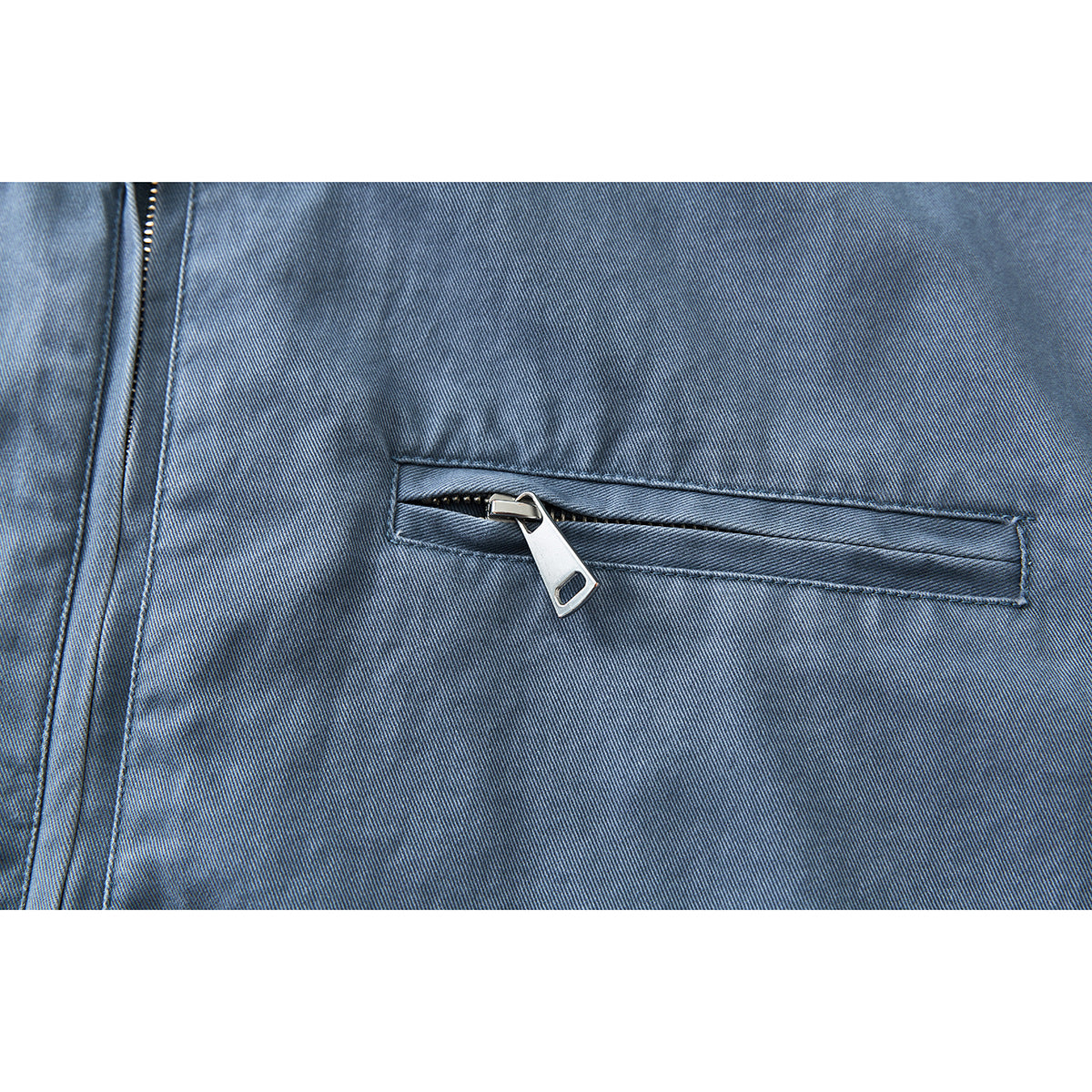 Close-up of a horizontal silver-zip pocket on the blue jacket.