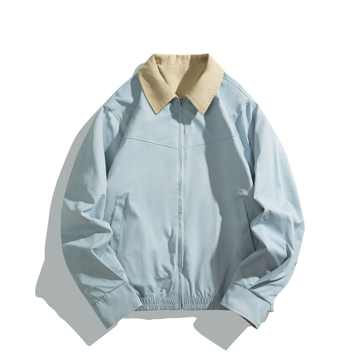 Light blue zip-front jacket with khaki contrast collar, elastic hem and slanted pockets, flat lay