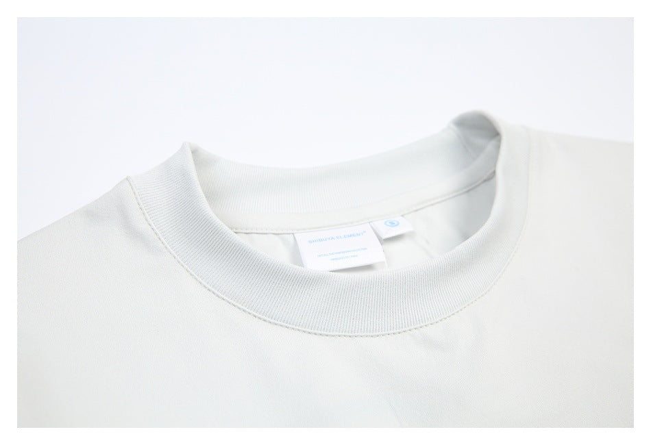 Close-up of an off-white crewneck collar and neckline, with small labels inside the back neck.