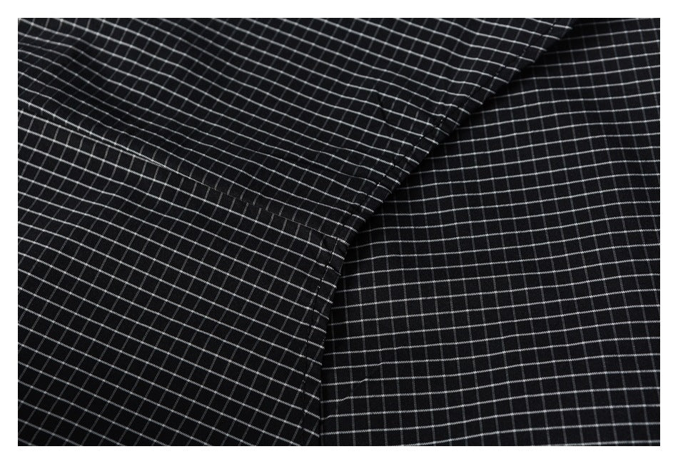 Close-up of black-and-white grid fabric showing a curved seam and adjoining panels.