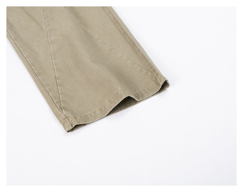Close-up of a tan trouser leg and stitched hem against a white background.