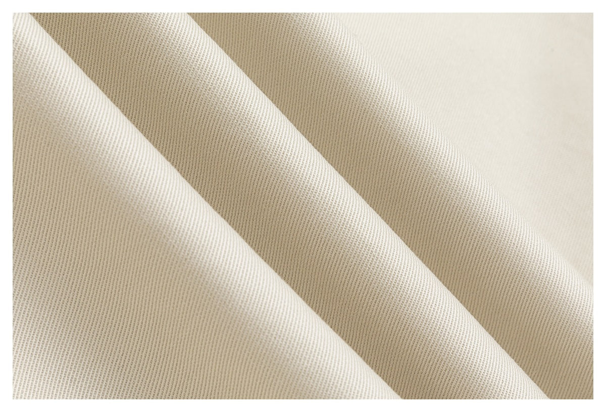 Close-up of ivory fabric arranged in soft folds, showing a fine, subtle ribbed texture.
