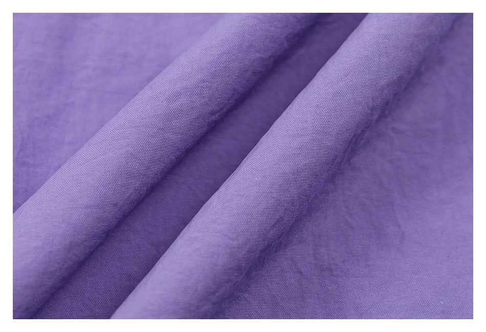 Close-up of lavender fabric folded to show its fine woven texture.