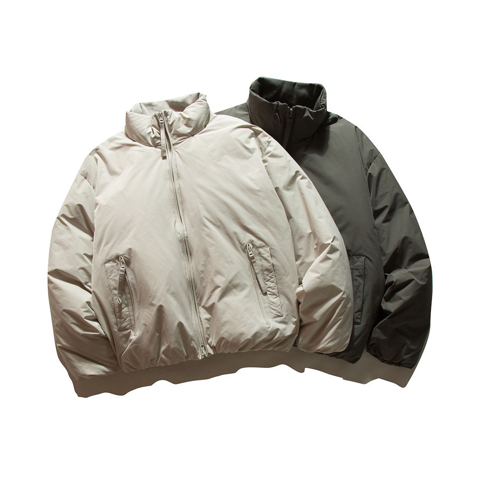 Two front-facing jackets shown together: one light beige and one dark charcoal, both with stand collars and front zippers.