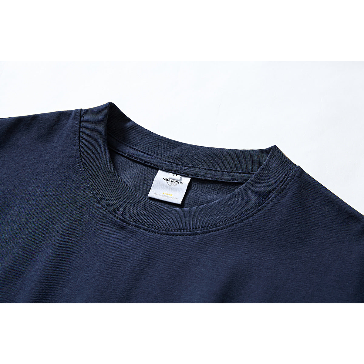 Close-up of a navy T-shirt's ribbed crew neck and inner label.