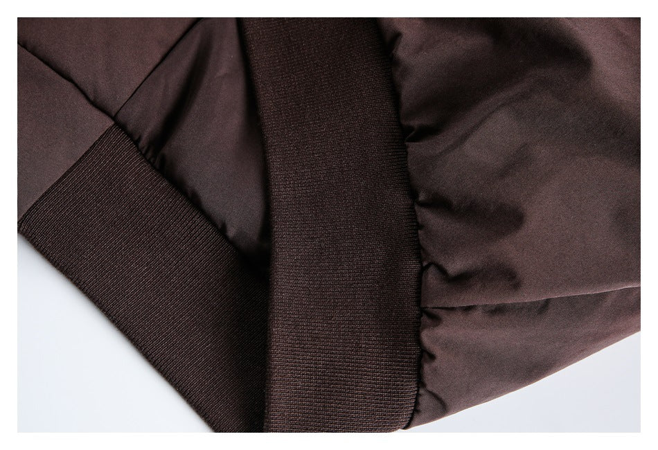 Close-up of a dark brown jacket hem with a wide ribbed knit band.